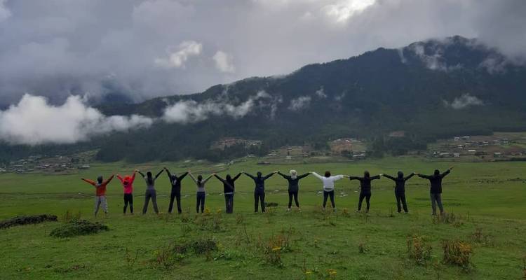 Group of people standing in a valley with misty mountains