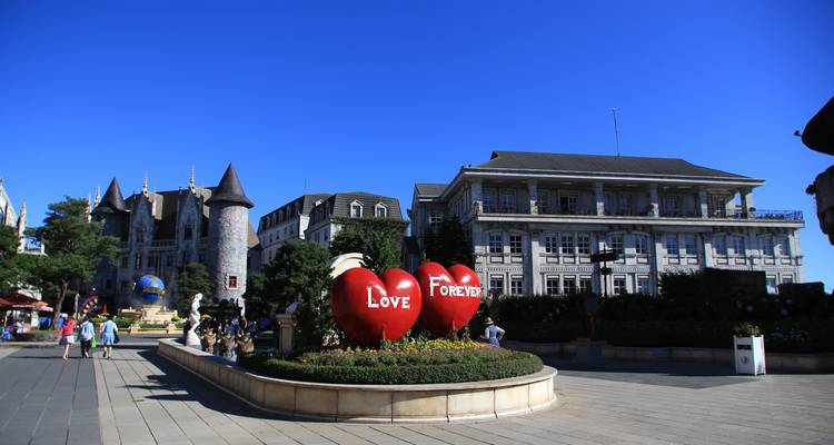 Zone de parc avec de grandes sculptures en forme de cœur et des personnes qui se promènent.