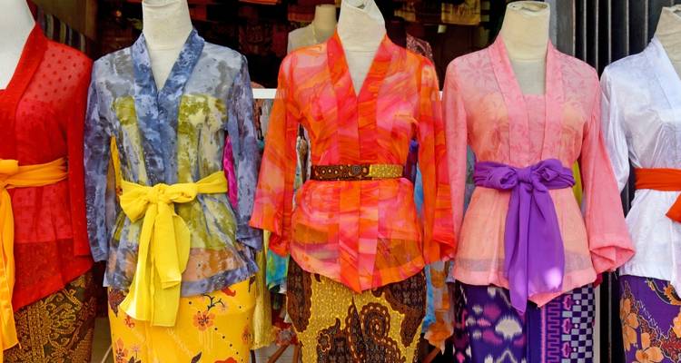 Des vêtements traditionnels colorés exposés sur un marché.