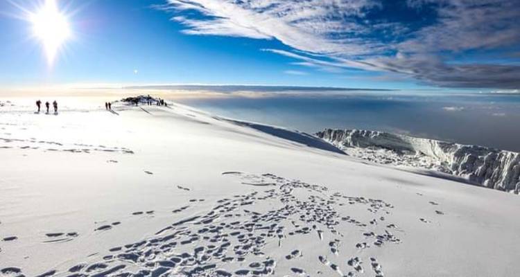 Hoogtebergbeklimmers in de sneeuw met een uitgestrekt berglandschap en heldere hemel.