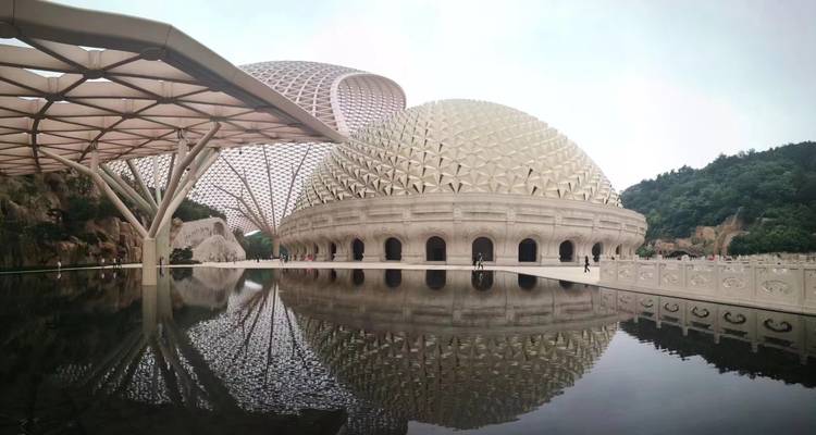 Modern architectural structures with domes and reflections in water.
