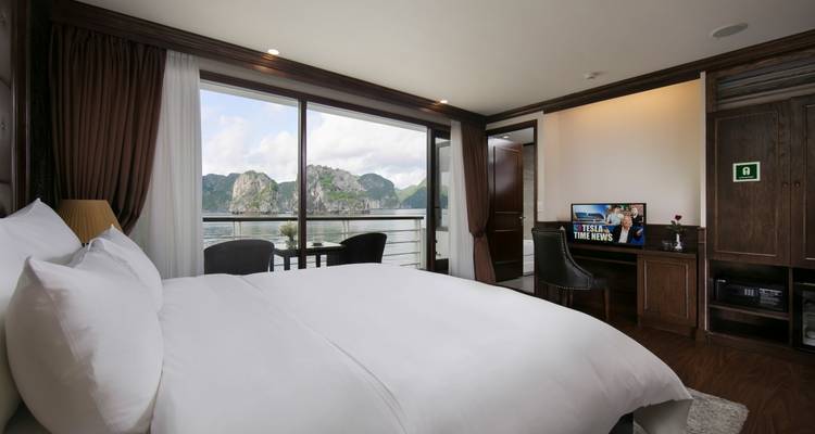 Luxury cruise cabin with a balcony and views of the sea.