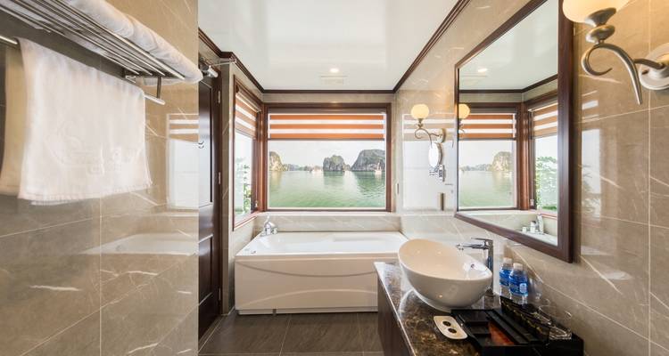 Cruise bathroom with luxurious amenities and large windows showing scenic views.