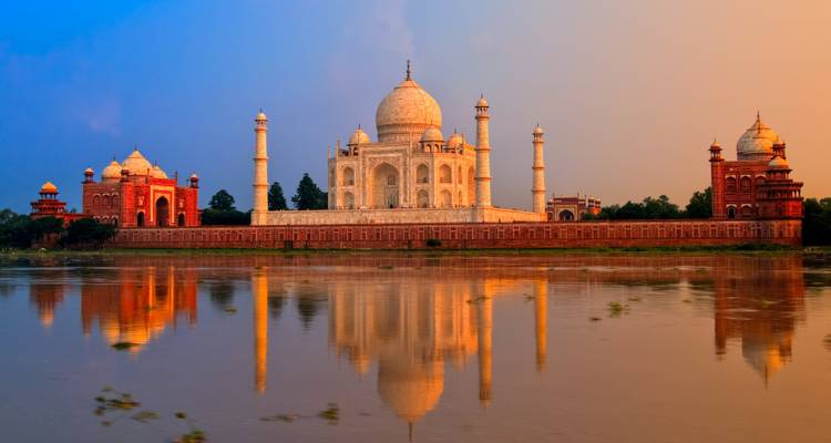 De Taj Mahal met zijn weerspiegeling in de Yamuna-rivier bij zonsondergang.