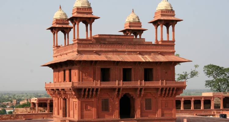 Een rode zandsteen historisch bouwwerk met sierlijke architectuur.