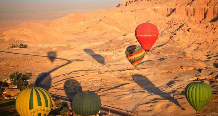 Heteluchtballonnen boven woestijnlandschap.