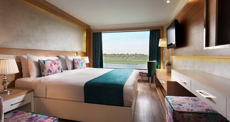 Luxuriöse Kreuzfahrtschiff-Kabine mit Blick auf den Fluss.