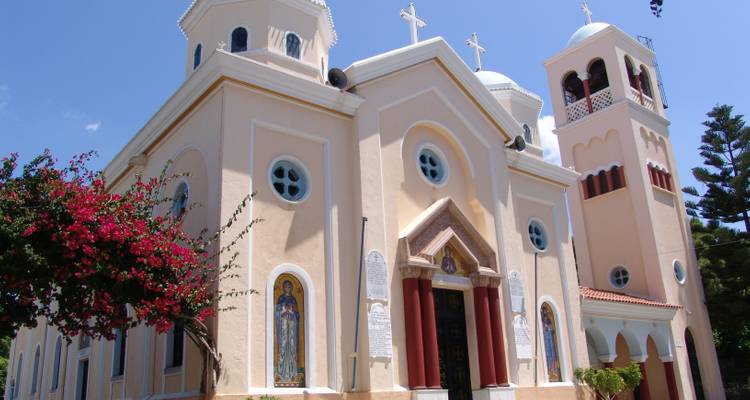 Una iglesia con una fachada colorida y flores florecientes.