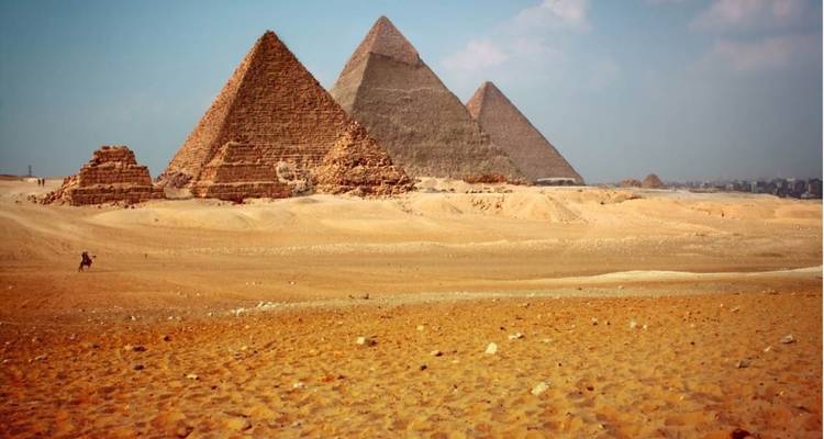Die ikonischen Pyramiden von Gizeh unter einem blauen Himmel.