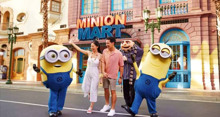 Ein Paar begruesst Minions vor dem farbenfrohen Minion Mart in den Universal Studios Singapur.