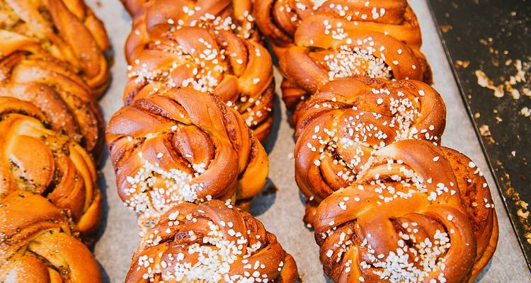 Close-up of freshly baked cinnamon rolls topped with pearl sugar.