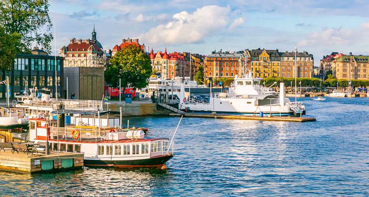 Boats on a waterway with a scenic view of colorful buildings in the city.