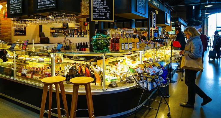 Indoor market with various food and drink products on display.