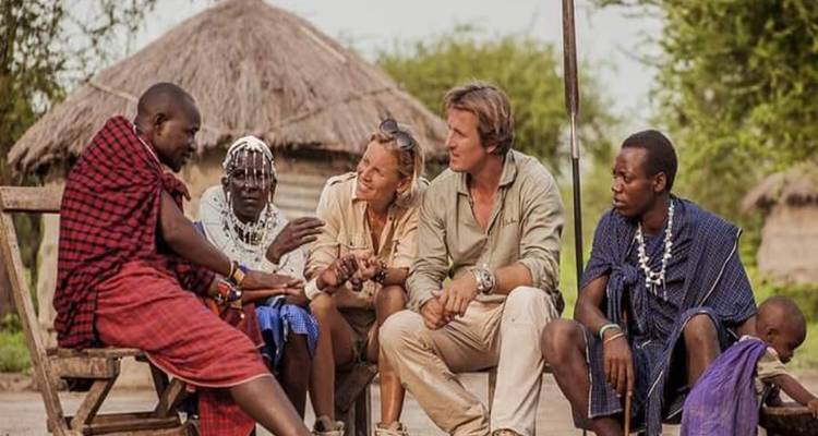 Groupe de personnes en conversation avec les villageois locaux.