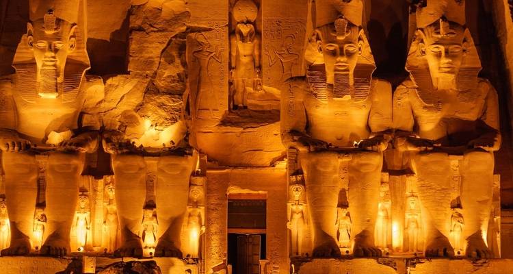 Standbeelden van farao's verlicht in de nacht in een oude Egyptische tempel