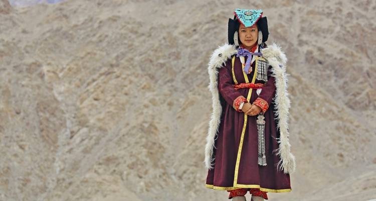 Person in traditional attire in mountainous area.