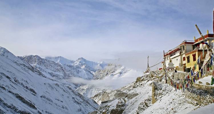 Snowy mountain monastery with prayer flags.
