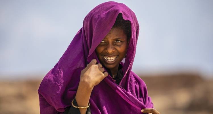 Persona con una bufanda morada sonriendo.