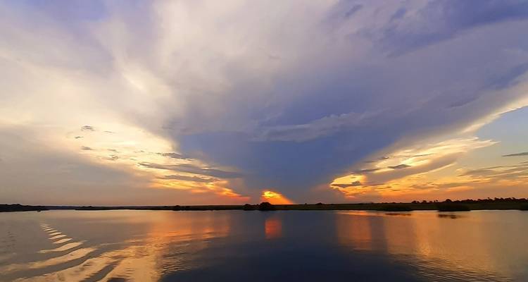 Sunset over a calm river with reflections.