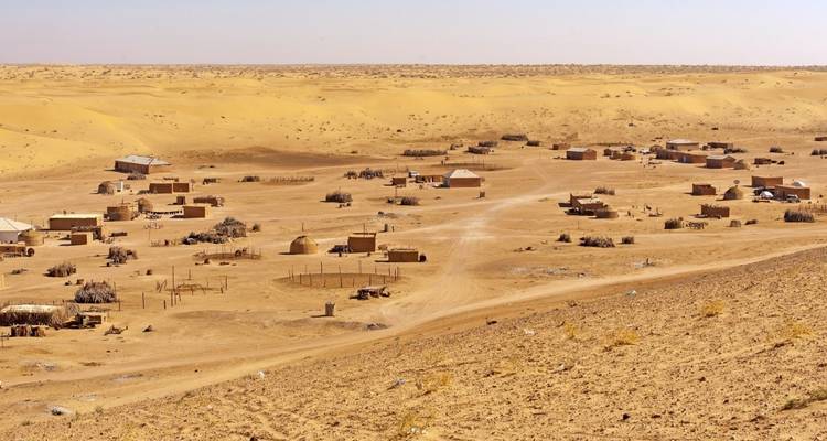 Desert village with scattered huts.