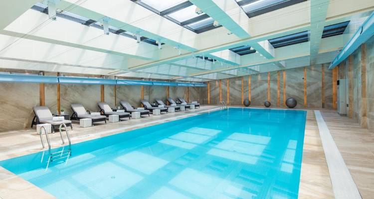Indoor swimming pool with lounge chairs.