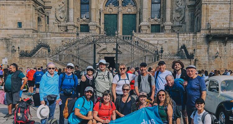 Un gran grupo del Camino celebrando con una pancarta fuera de la Catedral de Santiago de Compostela.