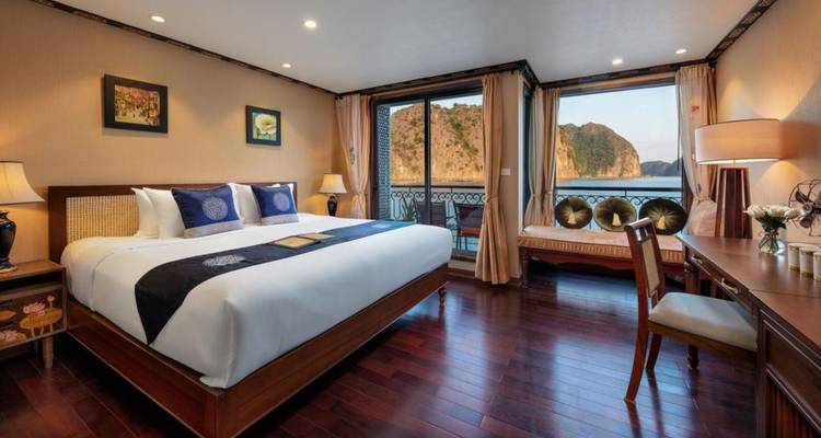 Ruime hotelkamer met grote ramen die uitzicht bieden op kalkstenen kliffen.