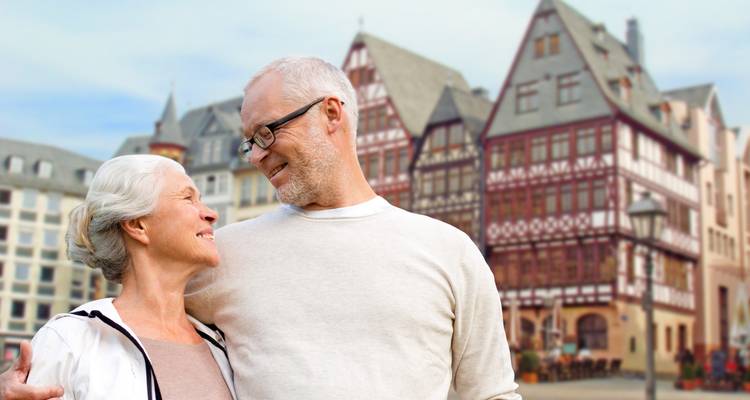 Happy couple embracing with historic buildings in the background.