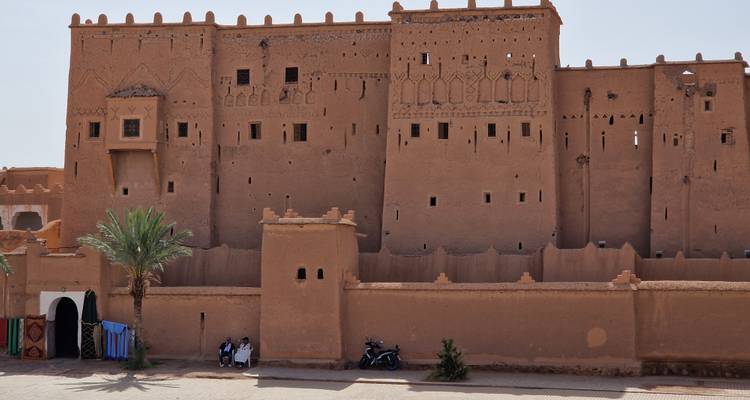 Une grande kasbah marocaine traditionnelle dans un paysage aride.