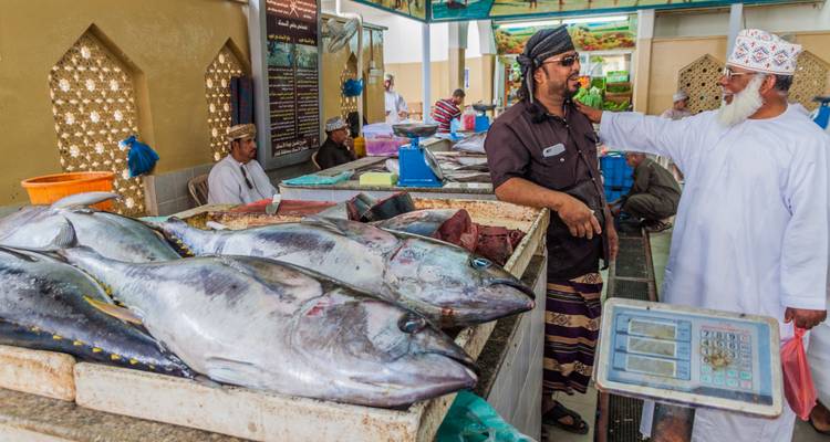 Marktscène met mannen bij een viskraam.