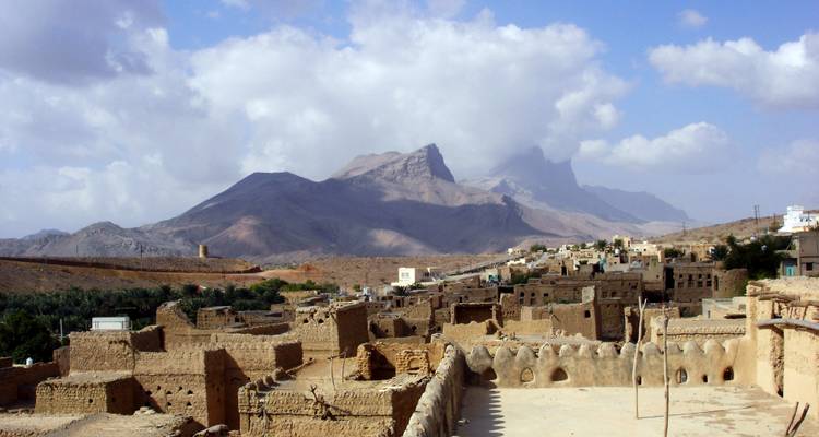 Zicht op een oud dorp met bergen op de achtergrond.