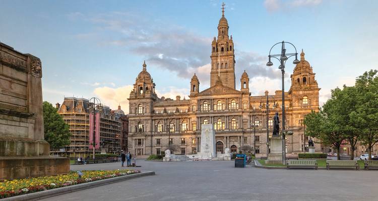 Plaza histórica de la ciudad con edificios ornamentados y una estatua.
