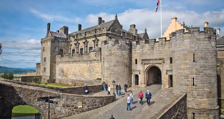 Visitantes en un castillo histórico con vistas panorámicas.