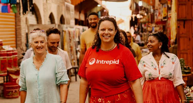 Dappere reisleider en reizigers wandelen door een levendige Marokkaanse souk-steeg