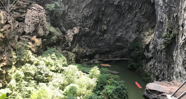 Canoes in a tranquil canyon with towering rock walls.