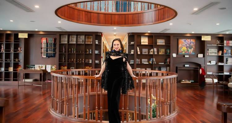 Vrouw in elegante kleding die poseert in een luxueus gebouw.