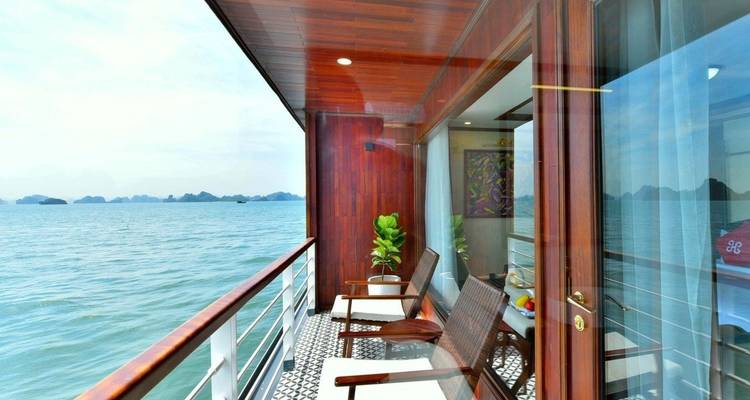 Balkonuitzicht met stoelen en een schilderachtige waterachtergrond.