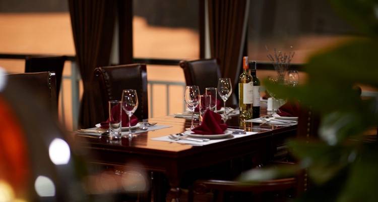 Close-up van een gedekte eettafel voor een intieme maaltijd bij schemering.