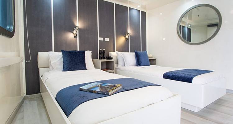 Interieur hut met twee eenpersoonsbedden en blauwe decoratie.