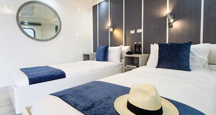 Hut met twee eenpersoonsbedden en nautische decoratieve accenten.