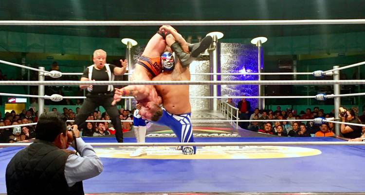 Wrestling match taking place in a ring with an audience.