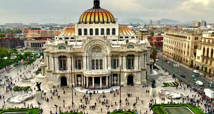 A large building with a dome surrounded by a busy plaza.
