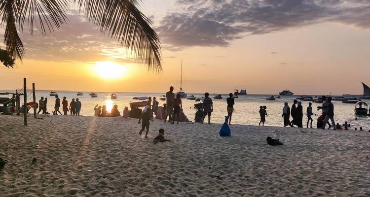 Des gens qui profitent d'un coucher de soleil sur la plage.