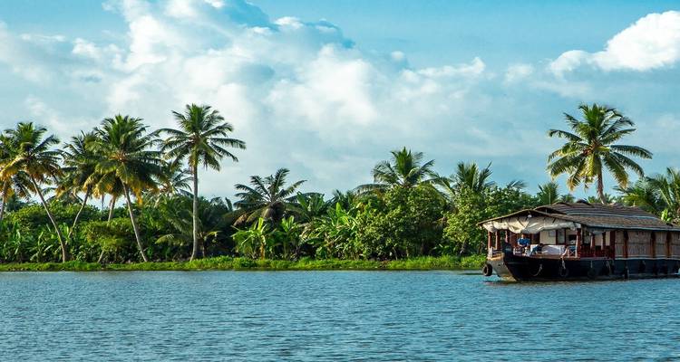 Péniche traditionnelle sur un bras mort serein avec des palmiers