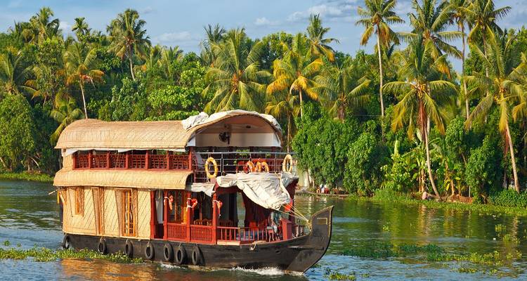 Péniche traditionnelle sur une rivière tropicale avec une végétation luxuriante.