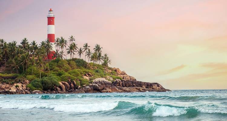 Phare sur une côte rocheuse au coucher du soleil avec des vagues océaniques.