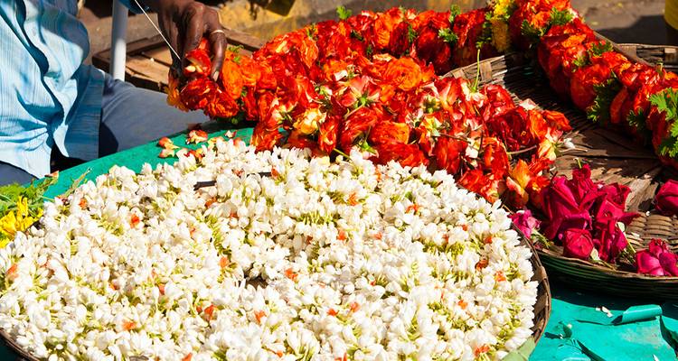 Ein Verkäufer, der Blumengirlanden für den Verkauf arrangiert.