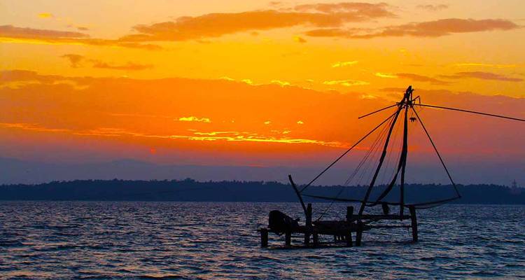 Fischereianlage als Silhouette vor einem leuchtenden Sonnenuntergang.
