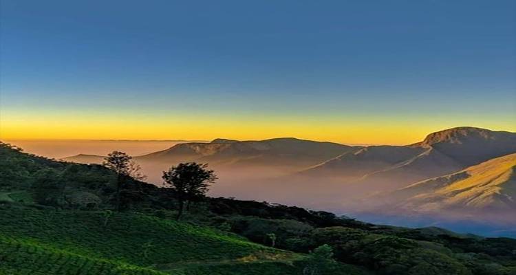 Malerische Aussicht auf Berge bei Sonnenuntergang mit einem klaren Farbverlauf am Himmel.