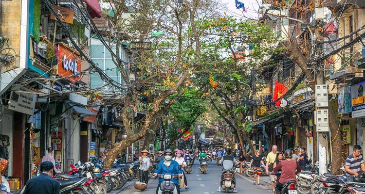 Geschäftige Straßenszene mit Motorrädern und Geschäften.
